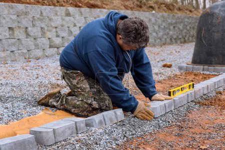 Photo for At construction site worker is installing arranging precast concrete pavers stones for sidewalk of road - Royalty Free Image
