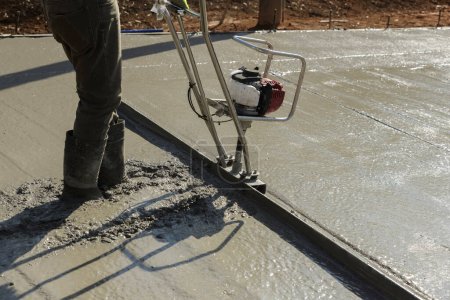 In construction new driveway machine is used to align fresh concrete layer of compacted layer