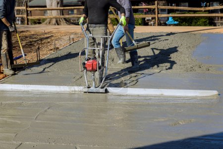 Photo for During construction of new driveway machine is used to align new concrete layer on compacted layer - Royalty Free Image