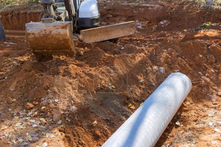 Foto de Worker preparing working with laying install concrete sewage pipes in ground is prevent subterranean flooding. - Imagen libre de derechos