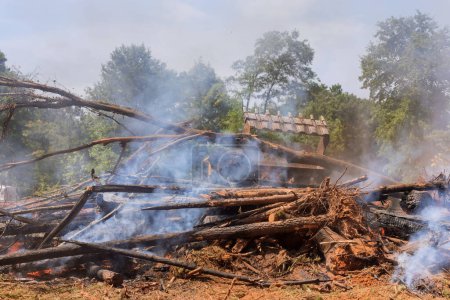 Téléchargez les photos : During construction of house uprooted forest was burned for construction of house to help build structure - en image libre de droit