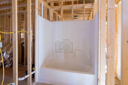Téléchargez les photos : Unfinished bathroom under construction home with installed bathtub in new house - en image libre de droit