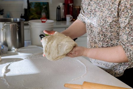Photo for Woman mixing yeast dough for making homemade donuts on white countertop - Royalty Free Image