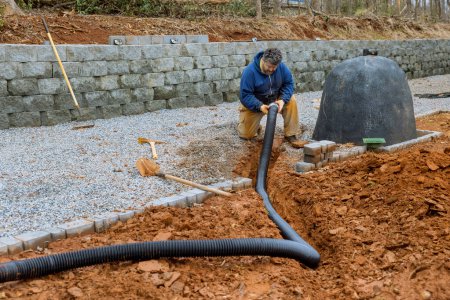 Foto de Laying drainage pipe for rain water on car parking lot is covered gravel with driveway - Imagen libre de derechos