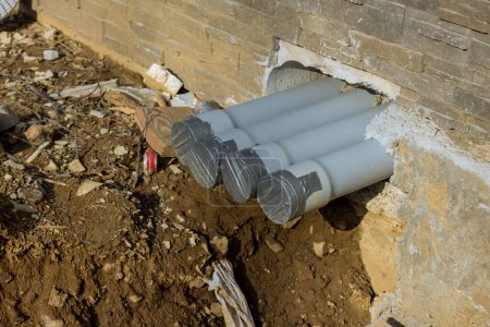 Foto de Instalación de nuevos tubos de alcantarillado de plástico en el suelo en la zanja durante el montaje - Imagen libre de derechos