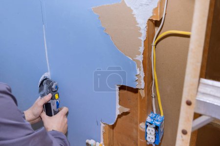 Téléchargez les photos : Un multi-outil oscillant a été utilisé pour couper une partie endommagée des travaux de rénovation dans la maison. - en image libre de droit