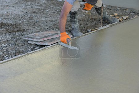 Foto de Uso de paletas de yeso trabajador suelo de cemento de hormigón húmedo después de que se ha vertido - Imagen libre de derechos