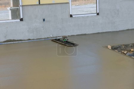 Foto de Después de verter de hormigón yeso trabajador piso de cemento de hormigón húmedo con paleta - Imagen libre de derechos