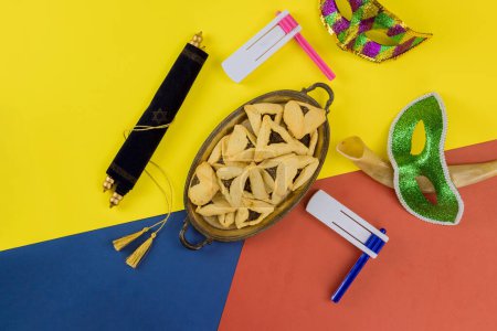 Foto de Jewish holiday of Purim to symbols Jewish celebration with hamantaschen cookies, tallit, carnival masks, noisemaker - Imagen libre de derechos