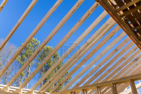 Téléchargez les photos : Ossature de toit en bois a été construit à partir de fermes lors de la construction de la nouvelle poutre bâton maison - en image libre de droit