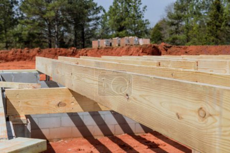 Layout of wood floor joists trusses on concrete block foundation for new custom home