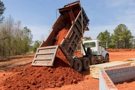 Téléchargez les photos : Sur le chantier de construction camion à benne est utilisé déplacer le sol vers le sol plat - en image libre de droit