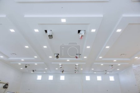 Foto de Instalar sistema de ventilación y aire acondicionado en casa, que ya ha sido pintado nuevos respiraderos se están instalando en el techo - Imagen libre de derechos