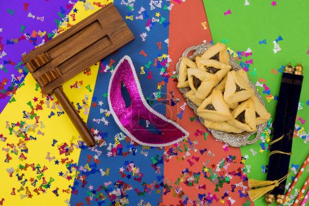 Noisemaker grogger, is traditional Purim symbol used to drown out name of Haman villainous character in Jewish holiday enjoy sweet hamantaschen cookies
