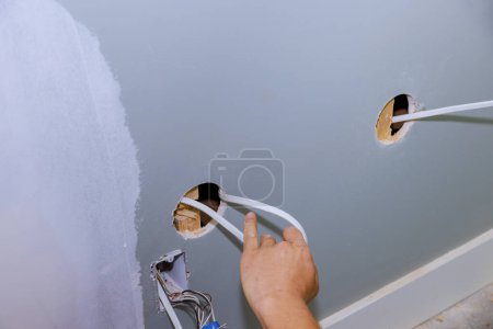 Photo for Work is being done safely on construction site for house by an electrician installing new current socket - Royalty Free Image