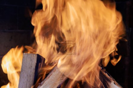 Téléchargez les photos : Pendant l'hiver, une atmosphère chaleureuse et confortable est créée par un feu de bois crépitant dans une cheminée rurale traditionnelle.. - en image libre de droit