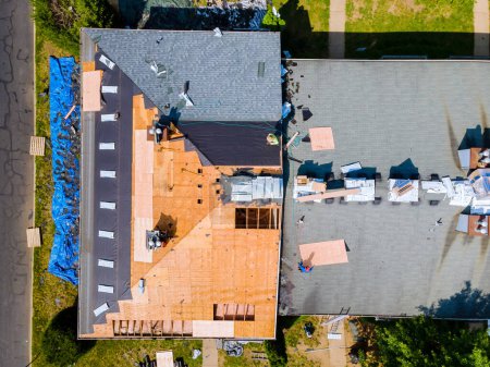Foto de Un techo del edificio de apartamentos fue reparado reemplazando el techo viejo con tejas nuevas y madera contrachapada - Imagen libre de derechos