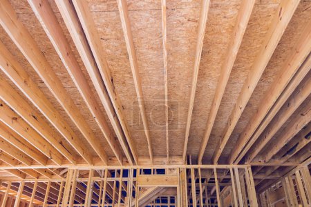 Photo for During construction of framing beam layout joists supports truss framework for wooden new house - Royalty Free Image