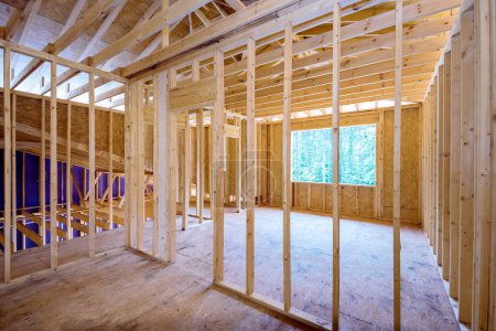 Photo for Interior of new house under construction with unfinished wooden framing beams on walls - Royalty Free Image