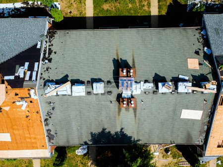 Téléchargez les photos : Réparations ont été la conduction sur le toit d'un immeuble d'habitation impliquant l'installation de nouveaux bardeaux pour remplacer les anciens - en image libre de droit