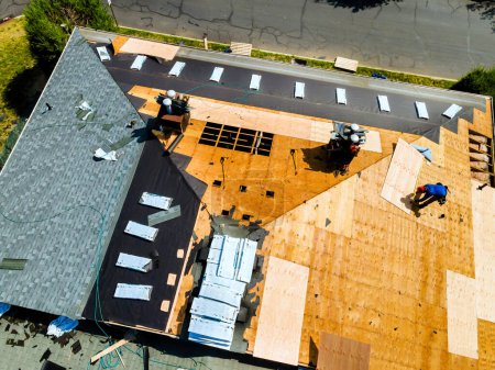 Photo for New shingles were installed and old ones were replaced plywood during process of repairing roof of apartment building. - Royalty Free Image