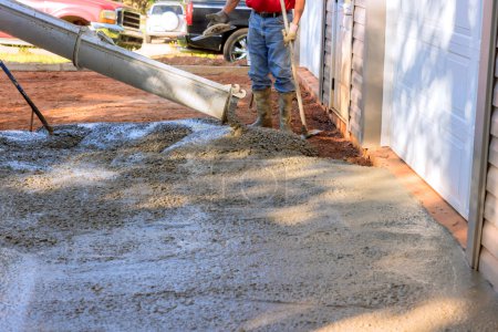 Mischwagen gießt nassen Zement bereit gemischten Beton in der Nähe von zu Hause, das gießt Beton für die Einfahrt
