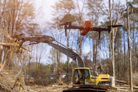 Photo for Drones are being used by environmental services to monitor uprooting trees in construction site - Royalty Free Image