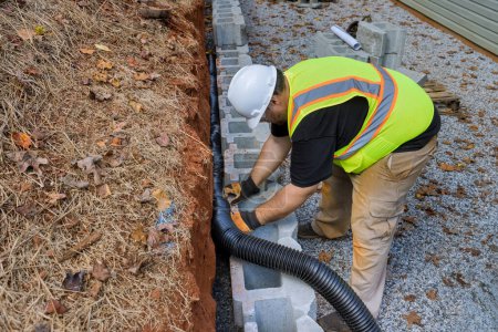 Téléchargez les photos : Projet de construction d'un tuyau de drainage pour l'eau de pluie dans le mur de soutènement. - en image libre de droit