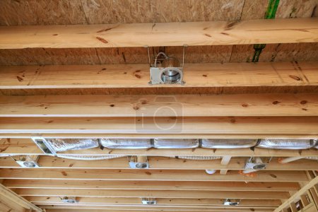 Photo for Installing of central conditioning set hvac system spotlight in new home on wooden beamed ceiling - Royalty Free Image