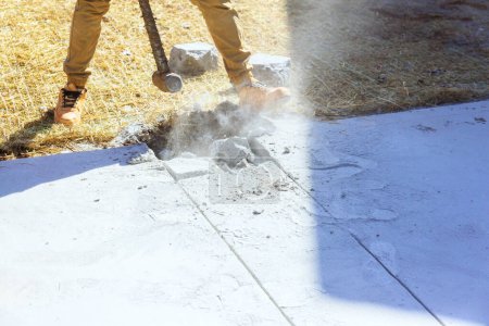 Téléchargez les photos : Marteau maniant travailleur brise l'ancienne allée en béton sur le chantier de construction - en image libre de droit