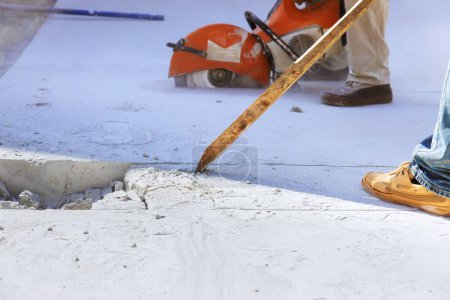 Téléchargez les photos : Un travailleur maniant démolit une ancienne allée en béton sur un chantier de construction - en image libre de droit
