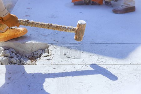 Téléchargez les photos : Travailleur sur chantier démolition d'une ancienne allée en béton avec marteau - en image libre de droit