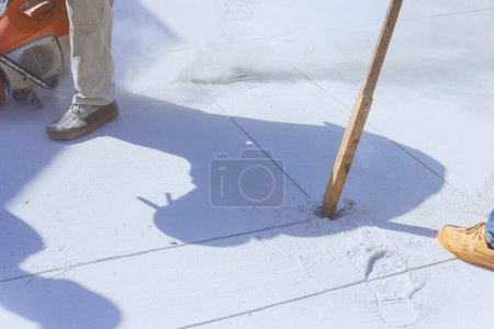 Téléchargez les photos : Vieil ouvrier brise-allée en béton démoli à l'aide d'une pioche sur le chantier - en image libre de droit