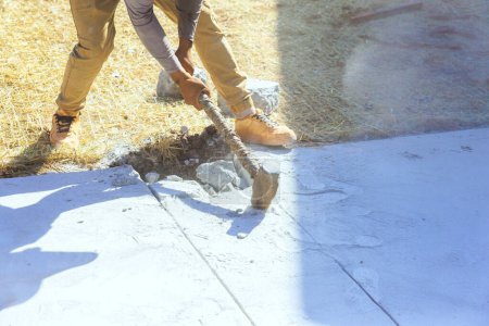 Téléchargez les photos : Travailleur de démolition avec marteau brise béton ancienne allée sur le chantier de construction - en image libre de droit