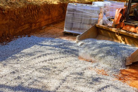 Mediante el uso de tractor, preparar la base de la nueva carretera por la colocación de grava de piedra triturada llena de piedra triturada