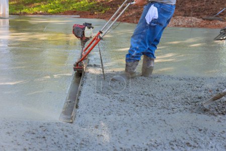 Photo for Fresh concrete driveway alignment using tamping machine for new driveway - Royalty Free Image