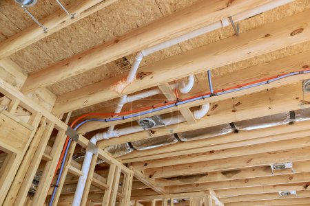 Téléchargez les photos : Nouvelle construction de maison installant le tuyau de drainage en plastique de PVC et le système de tuyauterie d'eau - en image libre de droit