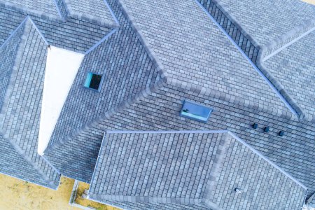 Photo for Construction roof of new house is being covered asphalt shingles while building - Royalty Free Image