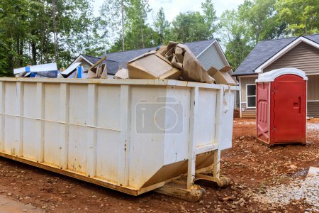 Photo for Dumpster full of construction waste debris is positioned near construction site. - Royalty Free Image