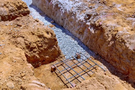 Photo for Trench prepared for cottage concrete deep strip foundation - Royalty Free Image