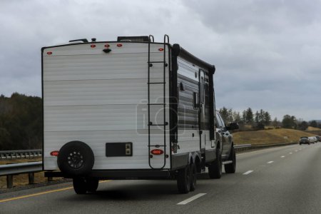 Traveling by caravan trailer on freeway road, family vacation, holiday trip in motorhome RV.