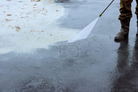 Téléchargez les photos : L'eau sous pression est utilisée pour nettoyer les rues avec un lavage humide - en image libre de droit