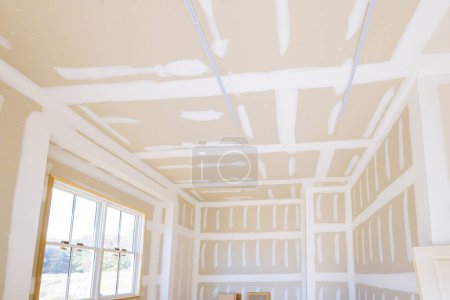 Foto de Acabado yeso paneles de yeso en listo para pintar con nueva casa en construcción - Imagen libre de derechos