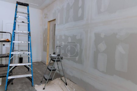 Téléchargez les photos : Plâtrage cloisons sèches est prêt pour la peinture dans une maison neuve qui est en construction - en image libre de droit