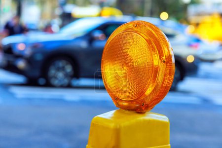 Photo for Detailed yellow warning orange construction light mounted on barricade intended for purpose of warning construction workers - Royalty Free Image