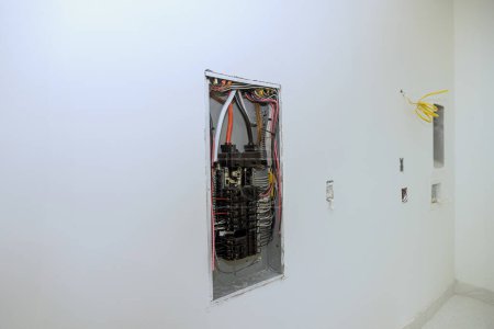 Photo for Electrical power control panel switch box is mounted to wooden frame beams on wall with circuit breaker mounted in it - Royalty Free Image