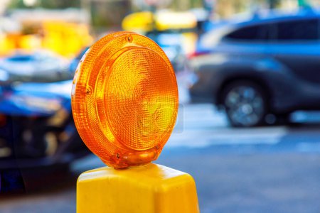 Photo for In road street under reconstruction, orange construction warning lights are displayed on barricade - Royalty Free Image