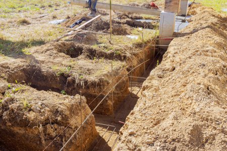 Photo for In preparation for pouring concrete into foundations, trenches are being dug - Royalty Free Image