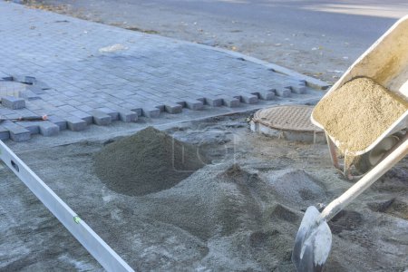 Téléchargez les photos : Déversement de sable de brouette pour la pose de pierres décoratives sur le sentier - en image libre de droit