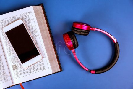 Photo for 24 DECEMBER 2023 Washington DC USA. Open Bible for study with headphones, smartphone on wooden table - Royalty Free Image